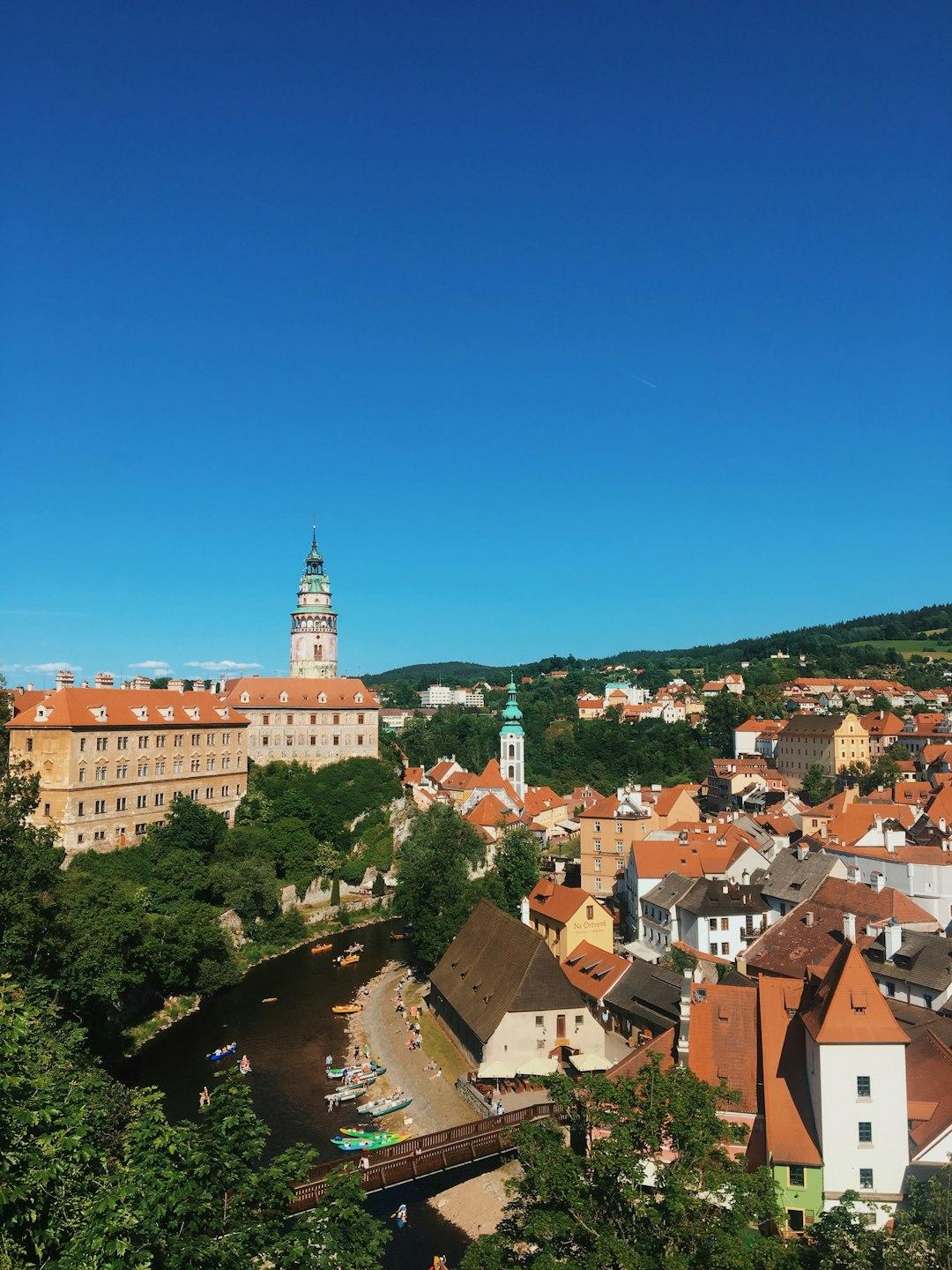Widok na historyczne miasto Český Krumlov, zamek, rzekę Wełtawę i kajaki.
