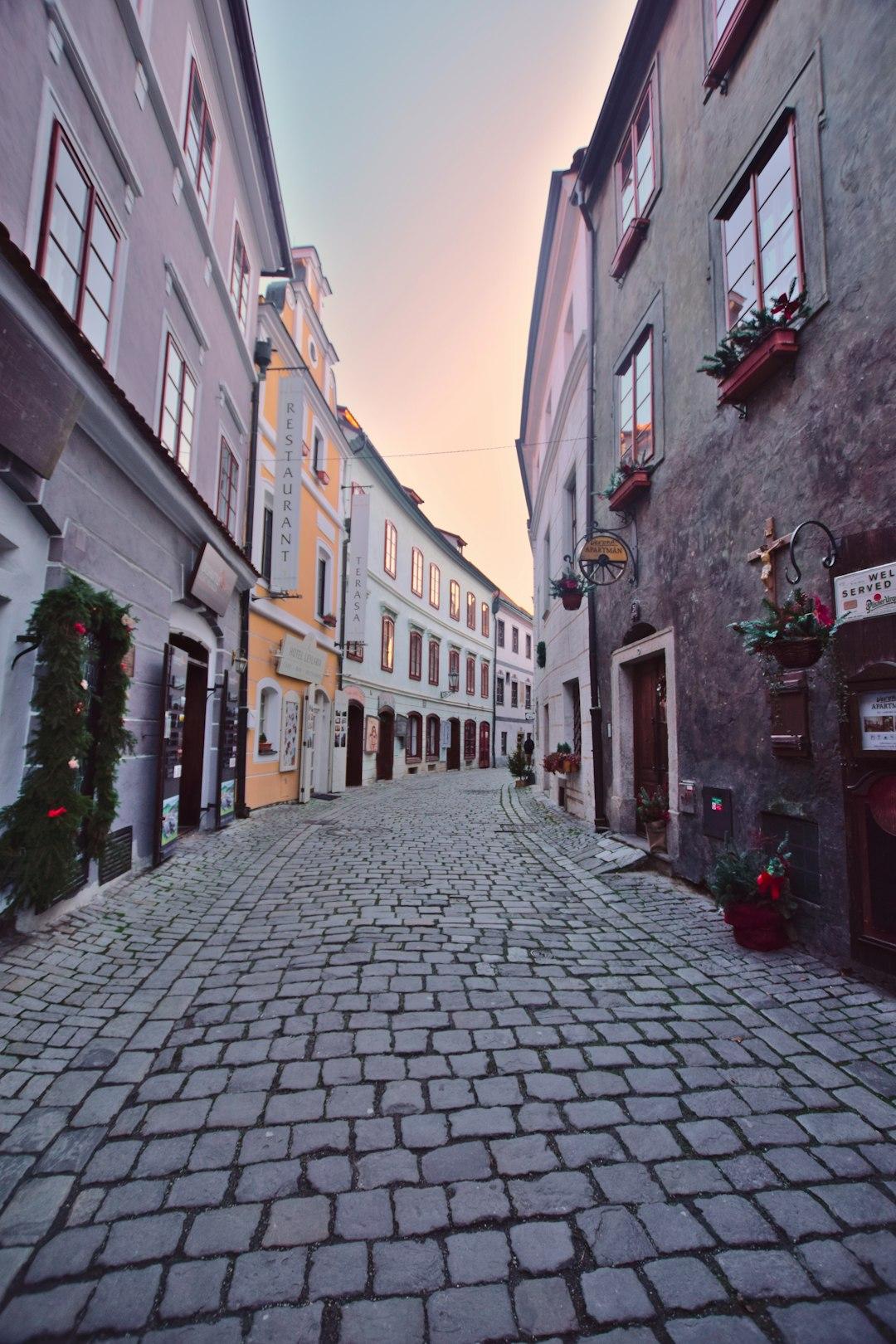 Zabytkowa brukowana ulica Czeskiego Krumlova o zachodzie słońca.