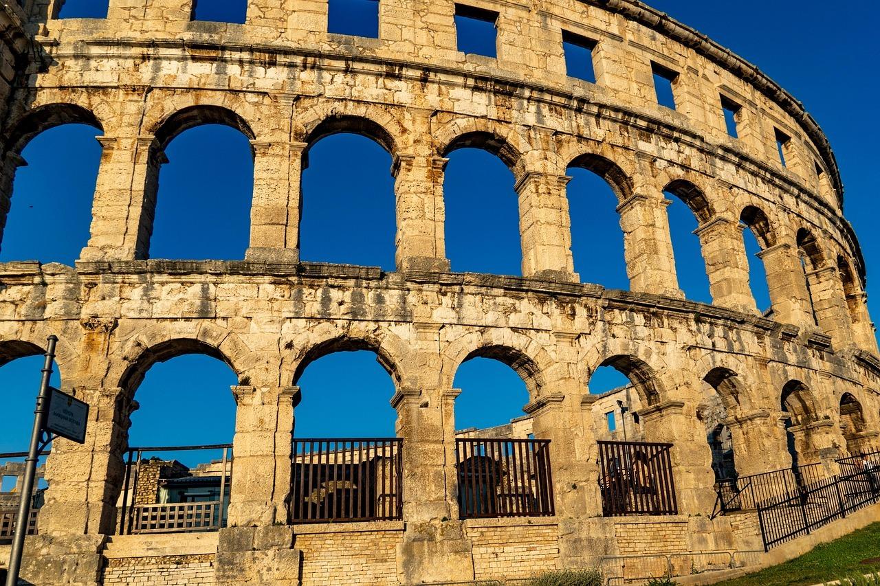 Rzymski amfiteatr Pula Arena, kamienne łuki pod błękitnym niebem.