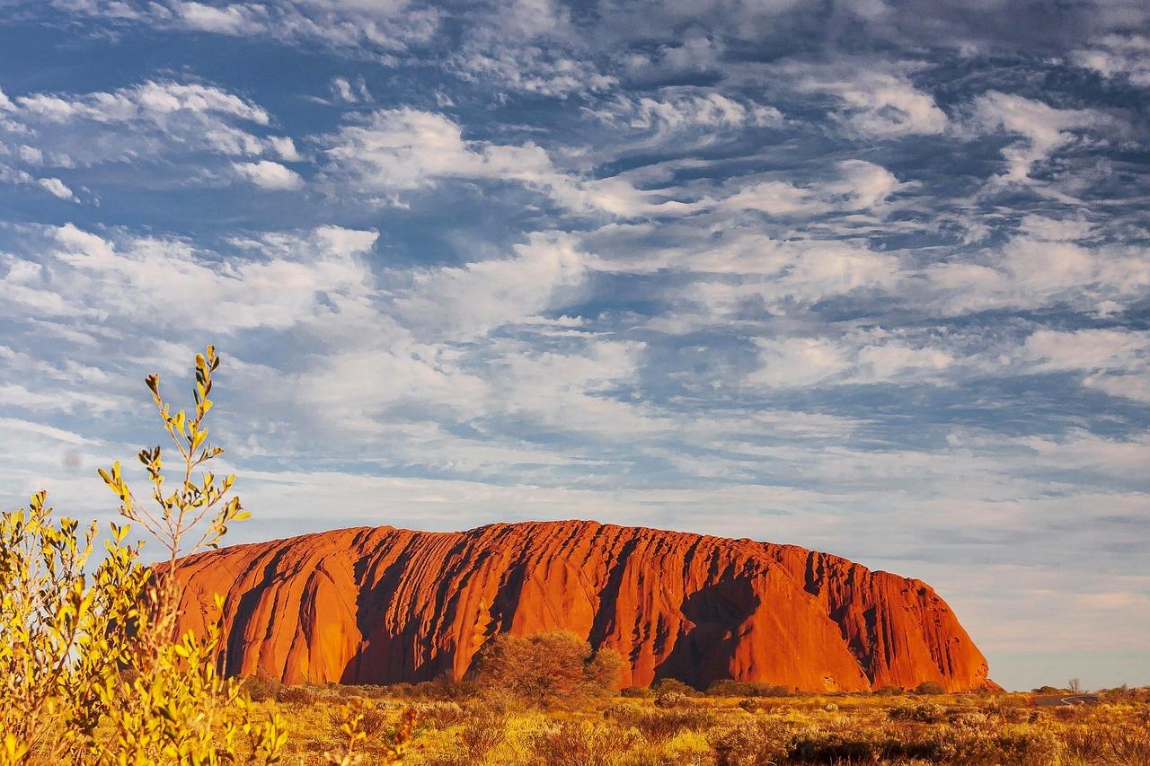 Zachód słońca nad Uluru, ikoniczną czerwoną skałą w australijskiej pustyni.