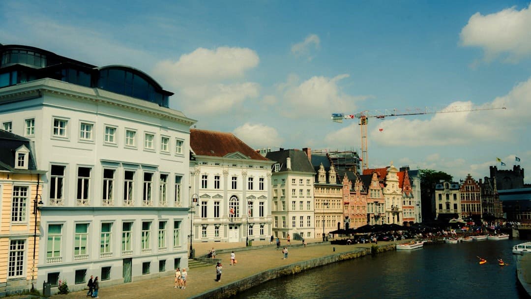 Europejskie miasto, kanał, zabytkowe kamienice, ludzie, kajaki, słoneczny dzień.