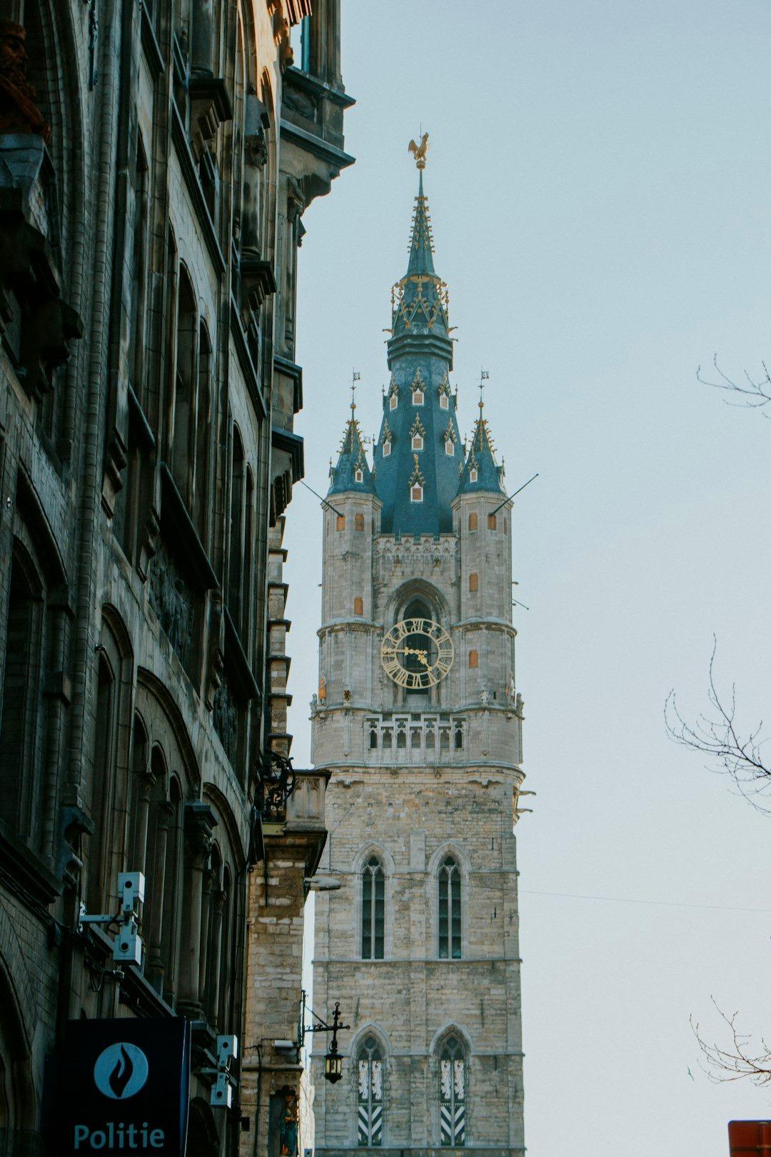 Gotycka dzwonnica w Gandawie z zegarem, historyczna architektura miejska.