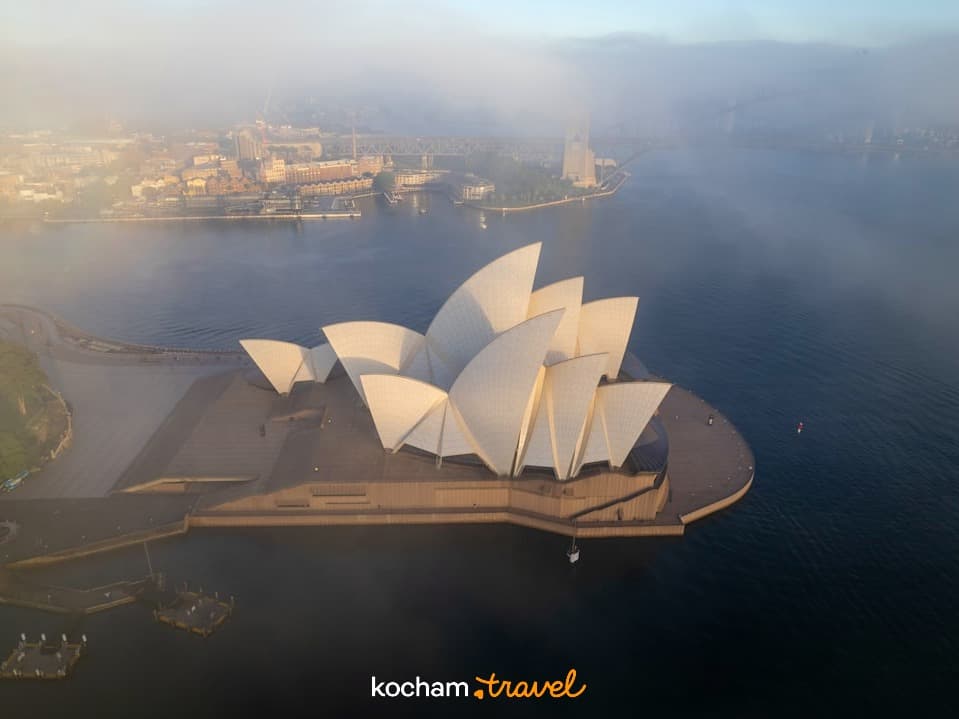 Opera w Sydney, mglisty poranek, panoramiczny widok portu w Australii.