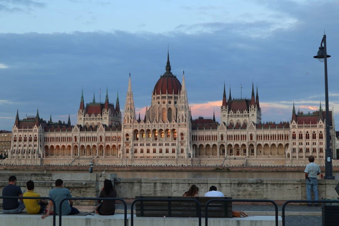 Oświetlony Węgierski Parlament w Budapeszcie o zmierzchu nad Dunajem.