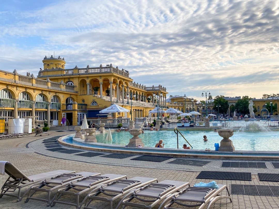 Kąpielisko termalne Szechenyi w Budapeszcie, żółty budynek, zewnętrzne baseny.