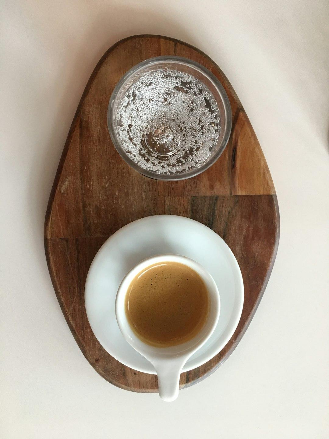 Filiżanka espresso i szklanka wody gazowanej na drewnianej desce