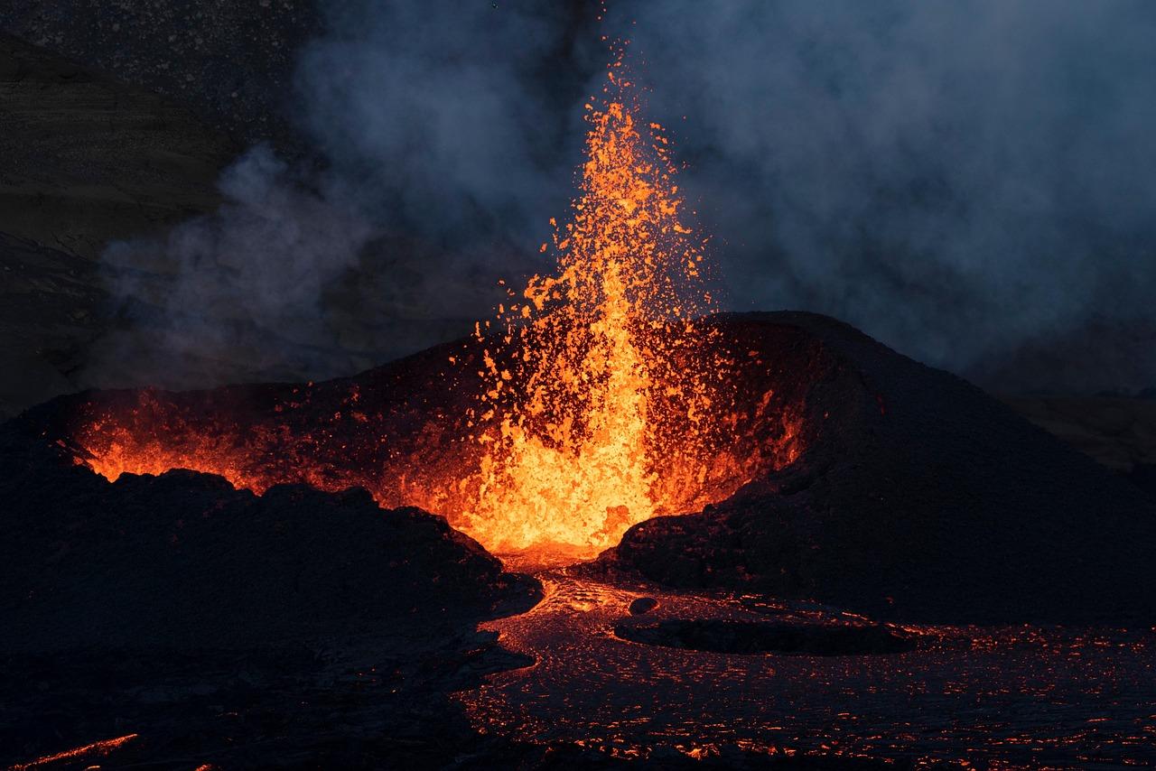 Wulkaniczna erupcja, strumienie płynnej lawy, dym, noc.