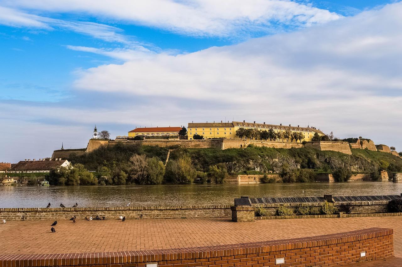 Historyczna Twierdza Petrovaradin z wieżą zegarową nad rzeką Dunaj.
