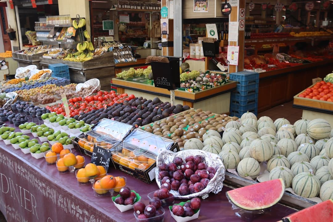 Świeże owoce i warzywa na targu: melony, śliwki, kiwi, pomidory.