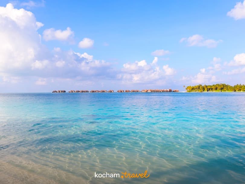 Rajska tropikalna plaża, turkusowa woda, luksusowe bungalowy na oceanie.