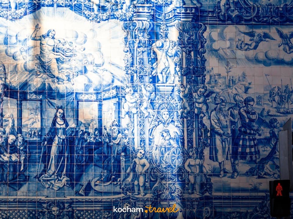 Niebiesko-biała ściana azulejos z motywami religijnymi, historycznymi, sygnalizacja świetlna.