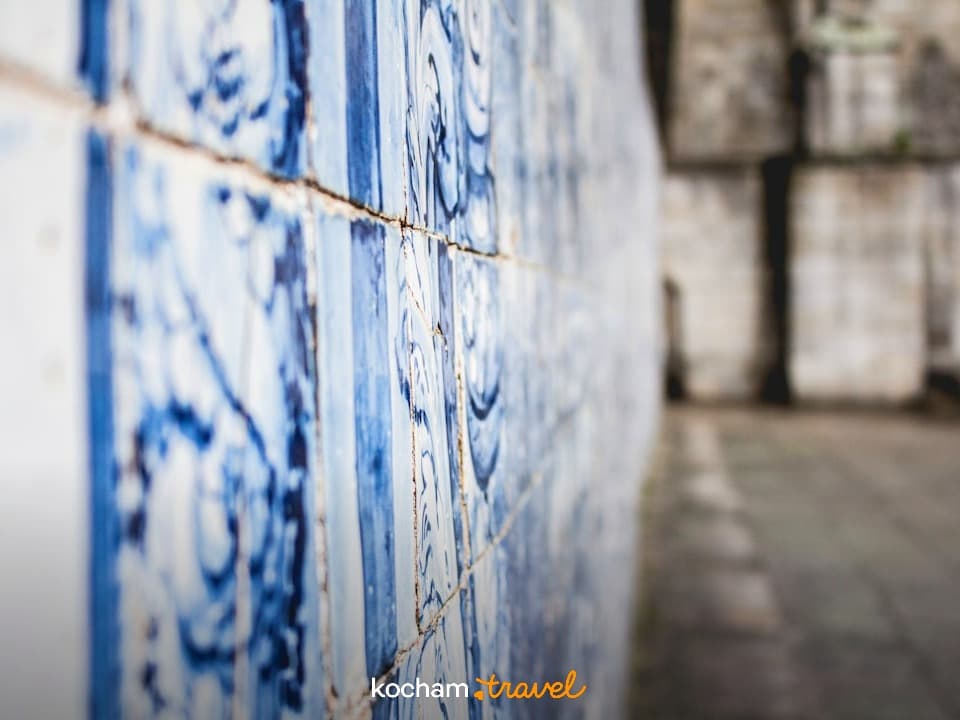 Niebiesko-białe płytki azulejos na ścianie historycznego budynku.