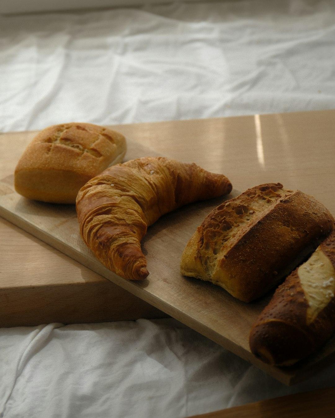 Różne rodzaje chleba i pieczywa na desce drewnianej.