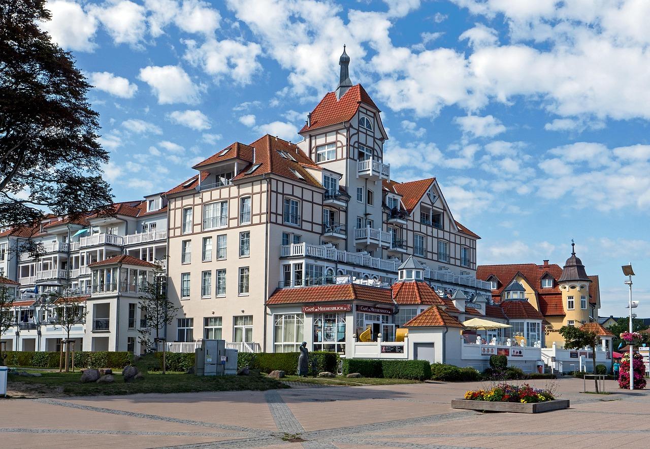 Tradycyjny nadmorski hotel z wieżą, balkonami i kawiarnią.
