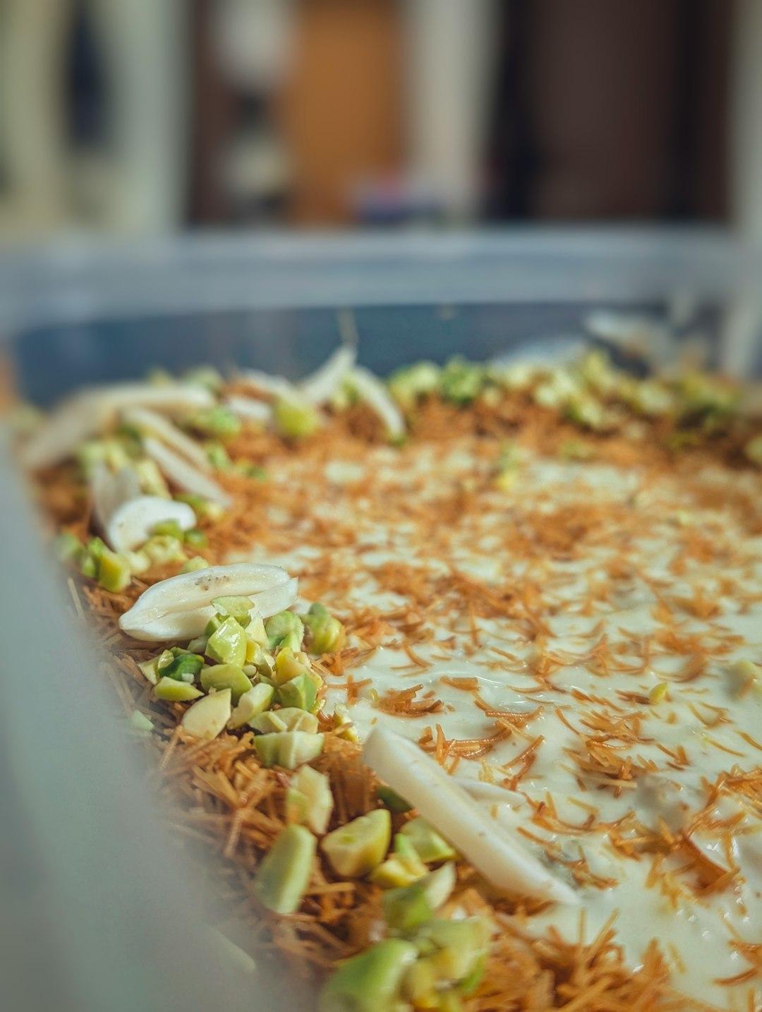Słodki deser kunafa z kremem, pistacjami, chrupiącymi makaronikami.