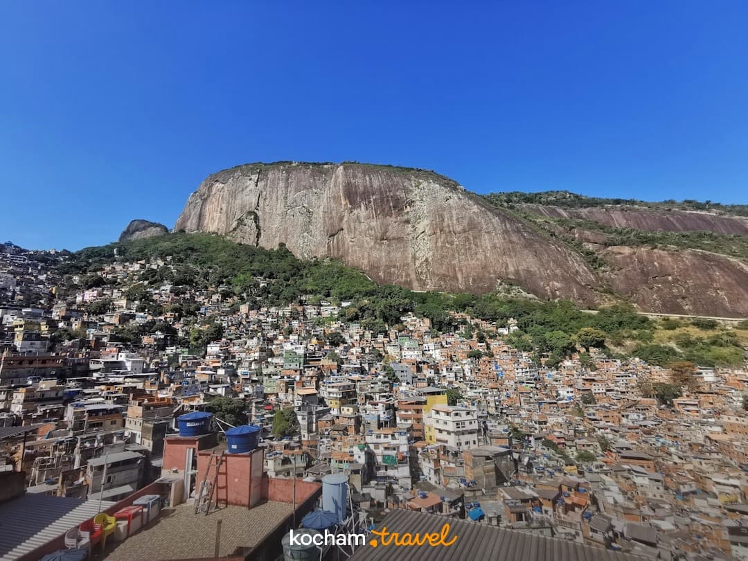 Kolorowa favela na wzgórzu pod wielką skalistą górą