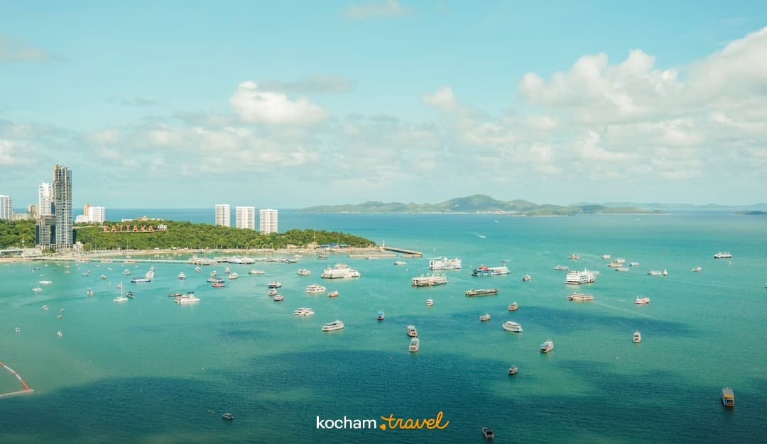 Pattaya, Tajlandia: panorama zatoki, turkusowa woda, miasto, liczne łodzie.