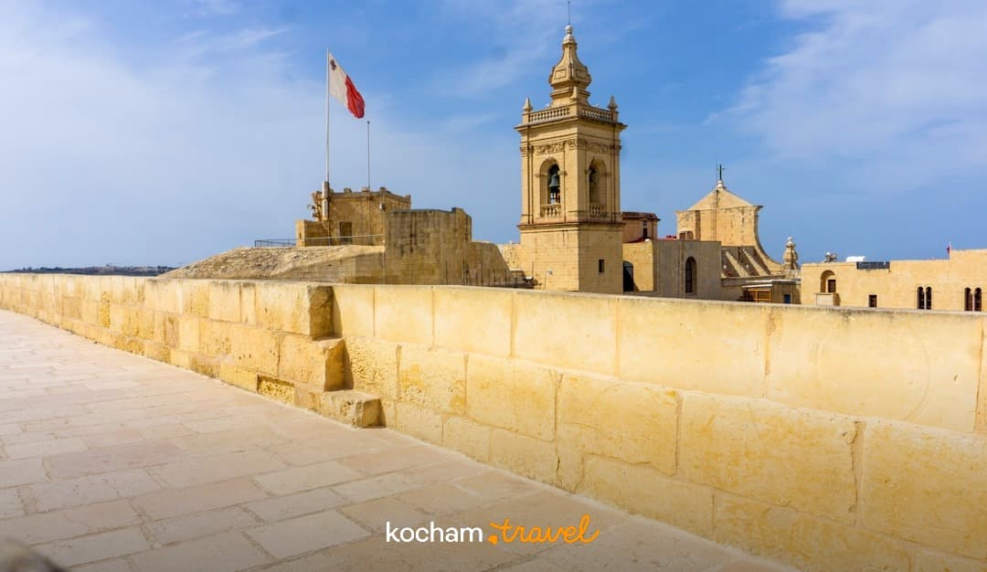 Malta, Cytadela, zabytkowe kamienne mury, dzwonnica, błękitne niebo.
