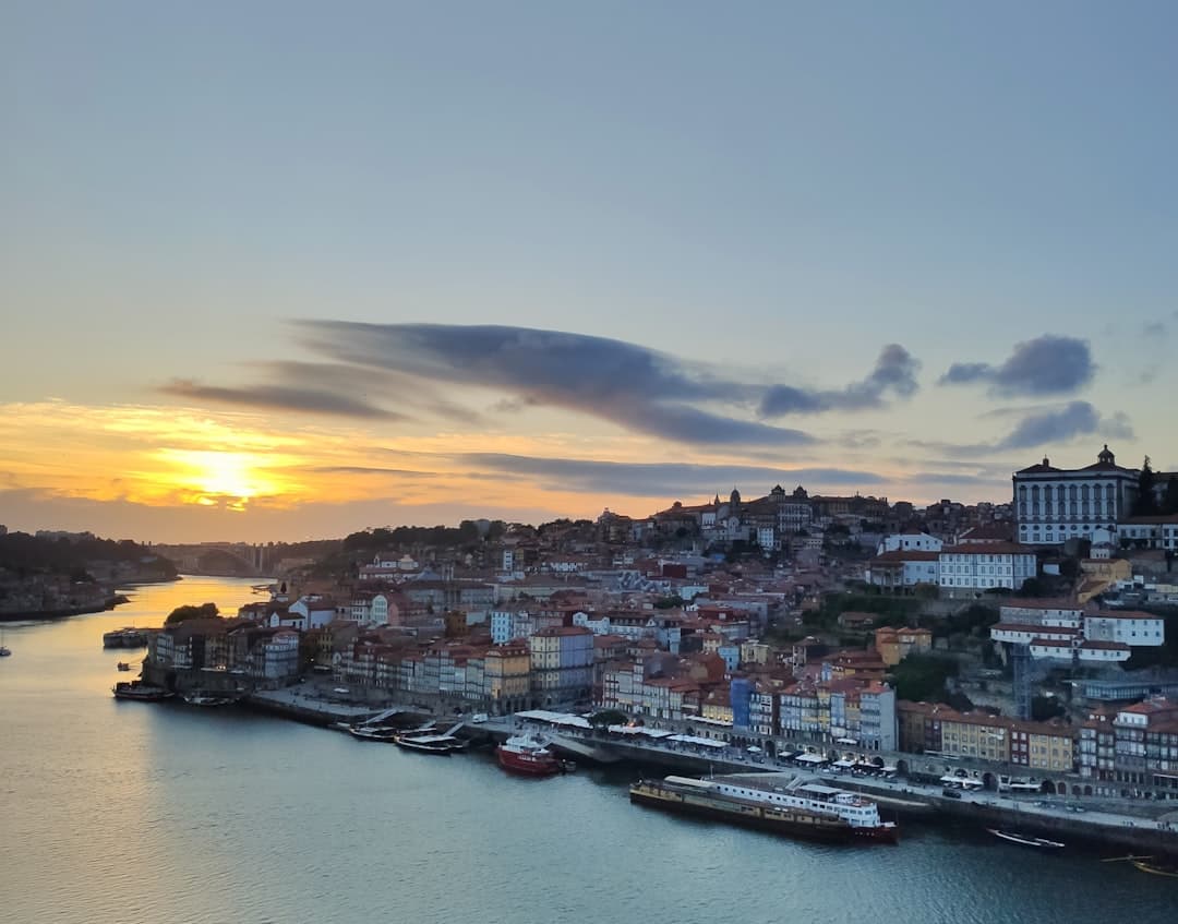 Malowniczy zachód słońca nad Porto z rzeką Douro i historycznymi budynkami.