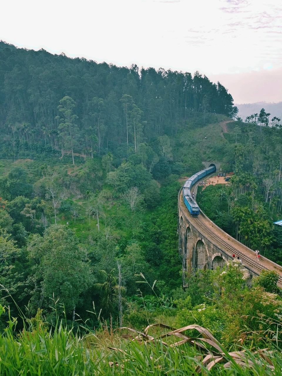 Niebieski pociąg na Moście Dziewięciu Łuków, panoramiczne zielone góry, Sri Lanka.