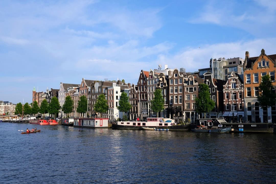 Kanał w Amsterdamie, kamienice, łodzie mieszkalne, słoneczny dzień, Holandia.