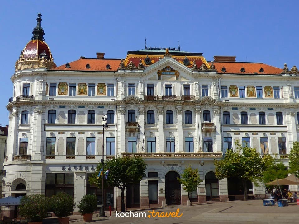 Ozdobny historyczny budynek na europejskim placu miejskim w słoneczny dzień.