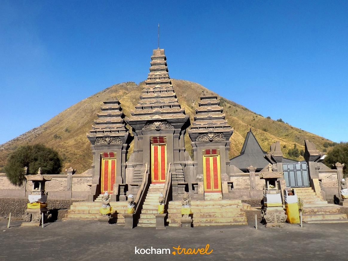 Tradycyjna świątynia Pura Luhur Poten na tle wulkanu Bromo, jasny dzień.