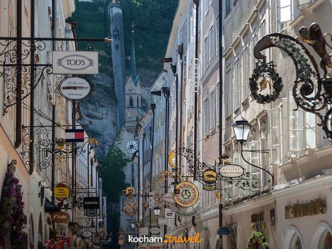 Wąska ulica Getreidegasse, Salzburg, tradycyjne szyldy, architektura miejska.