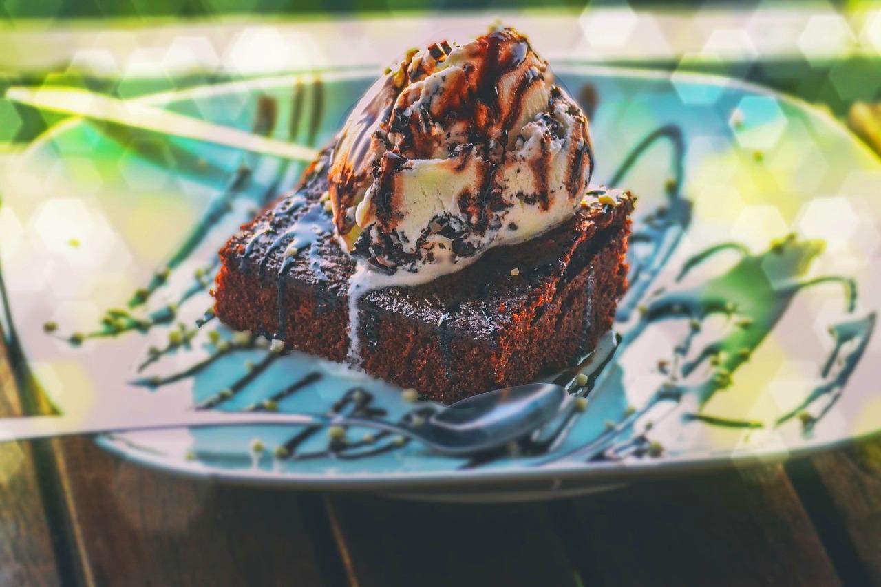 Czekoladowe brownie z lodami waniliowymi, polane sosem czekoladowym.