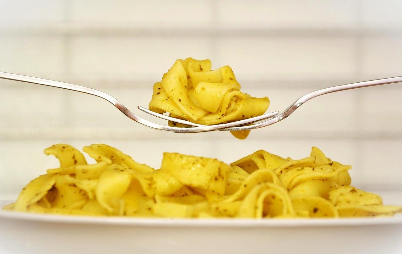 Makaron pesto na widelcu, świeże danie obiadowe, kuchnia włoska.
