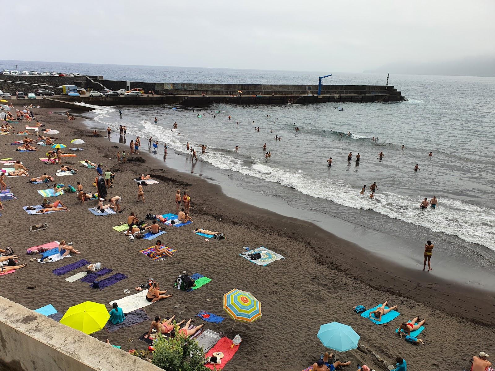 Plaża z ludźmi i morzem, kolorowe parasole, piasek.
