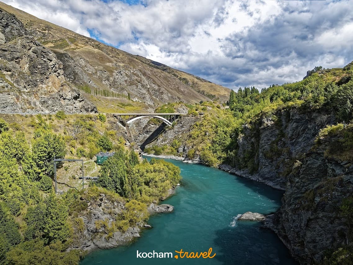 Malowniczy most Kawarau nad turkusową rzeką w górzystym wąwozie Nowej Zelandii.