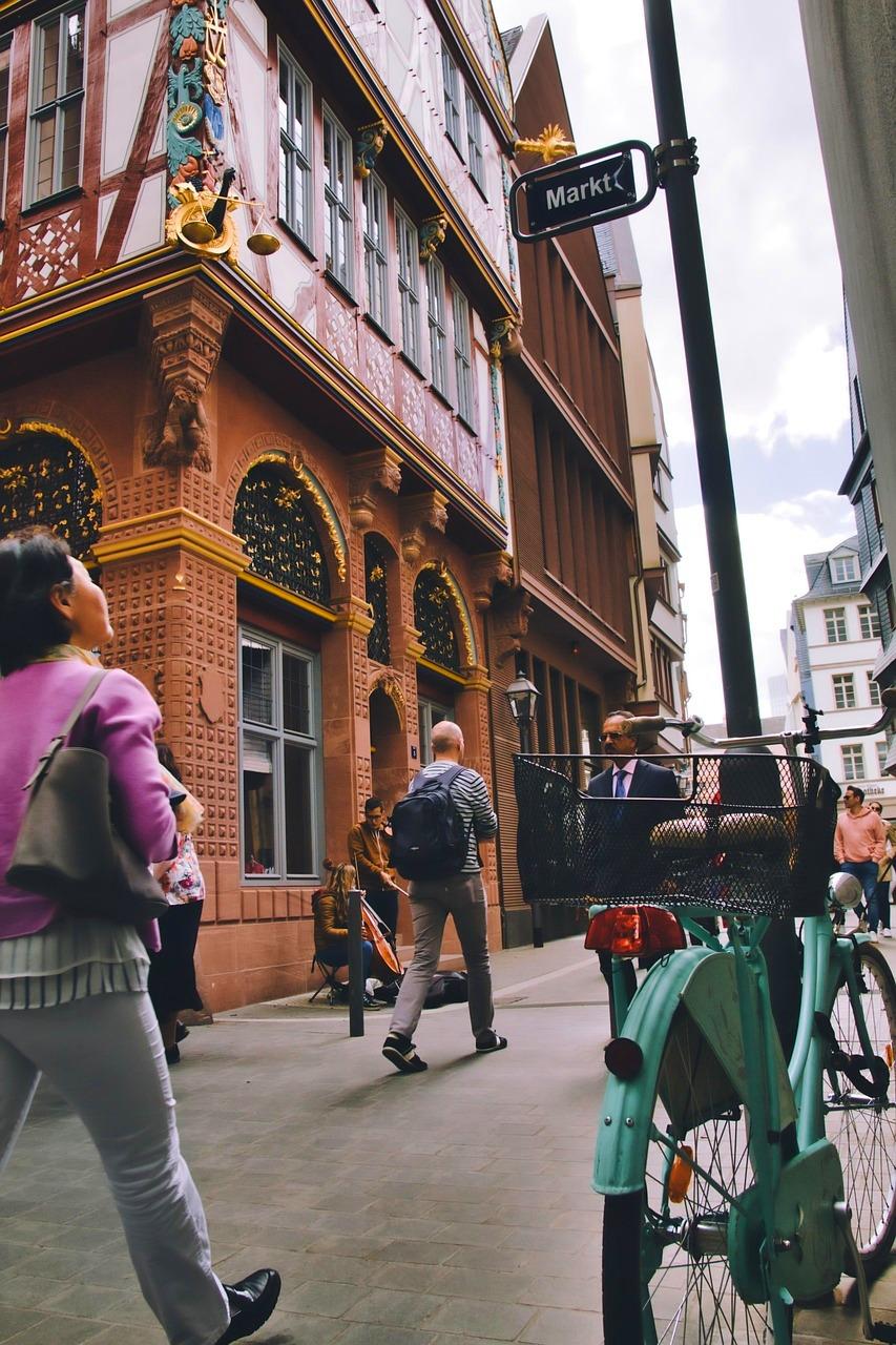 Zabytkowa ulica, ludzie, rower, tradycyjna architektura, znak Markt.