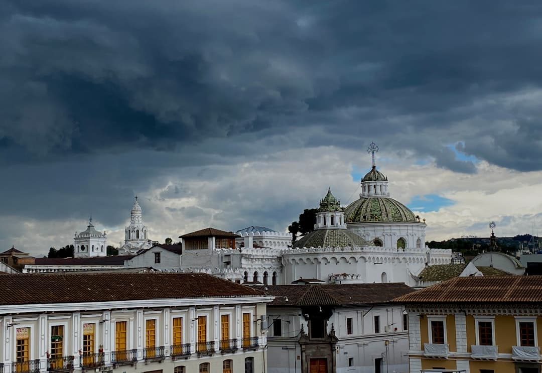 Historyczne miasto Quito, Ekwador, z kopułami kościołów pod burzowym niebem.