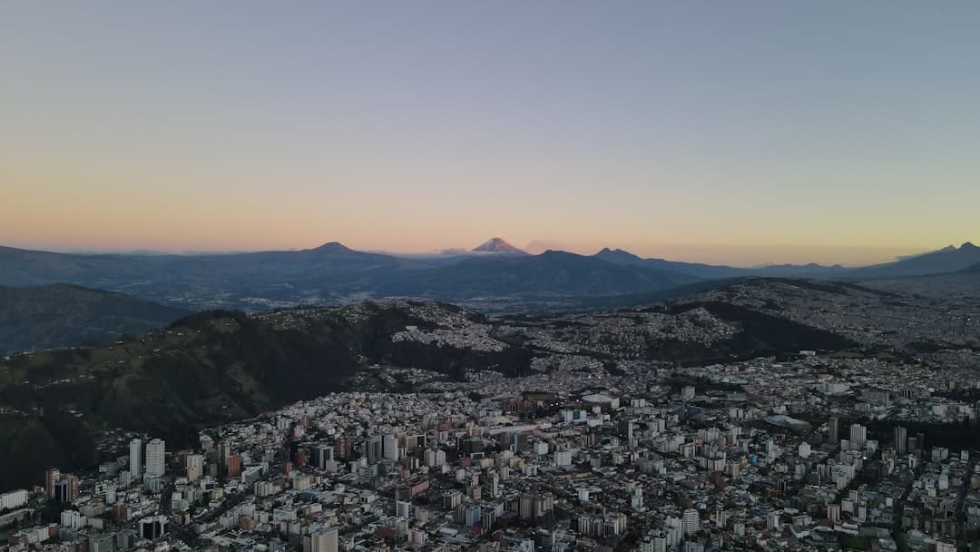 Panorama miasta Quito, góry, wulkan Cotopaxi o zachodzie słońca.