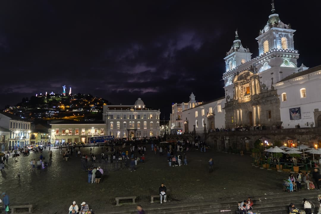 Historyczny plac Quito nocą z Kościołem San Francisco i figurą.