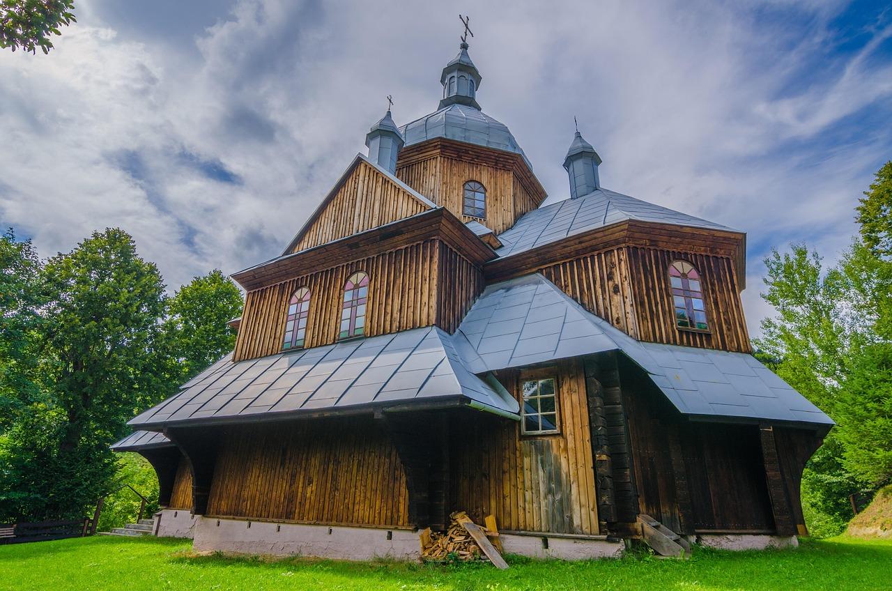 Zabytkowa drewniana cerkiew w górskim krajobrazie, polska architektura.