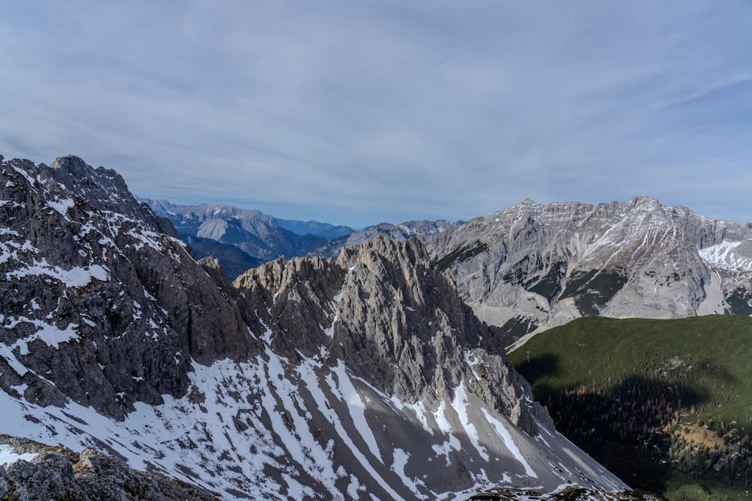 Majestatyczne góry pokryte śniegiem, panorama alpejskiego krajobrazu w świetle dziennym.