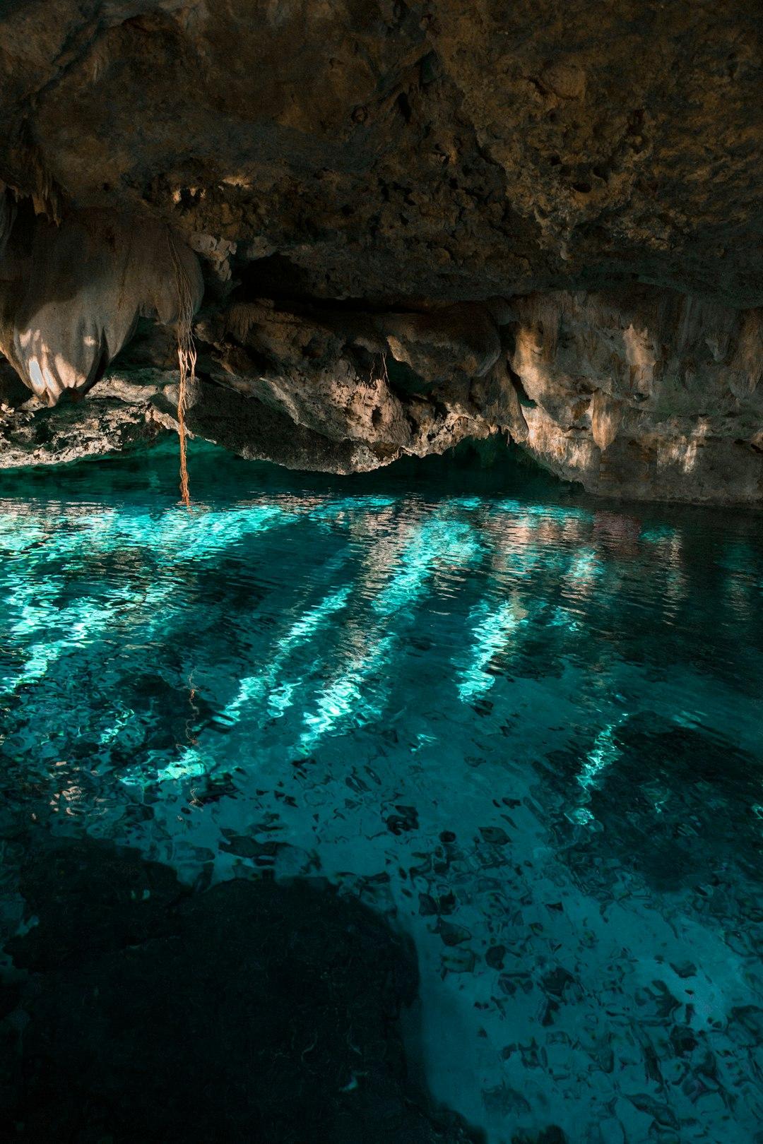 Przejrzysta turkusowa woda w jaskini cenote z odbiciami światła.