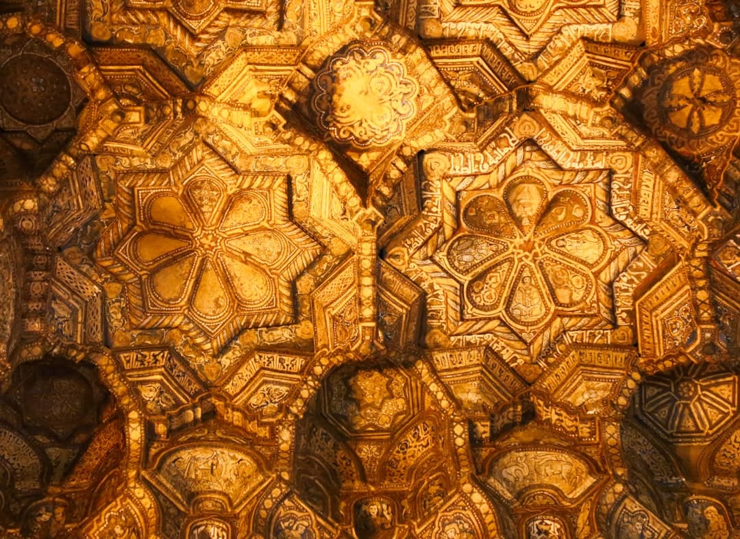 Skomplikowane złote zdobienia architektoniczne, geometryczne i roślinne wzory.