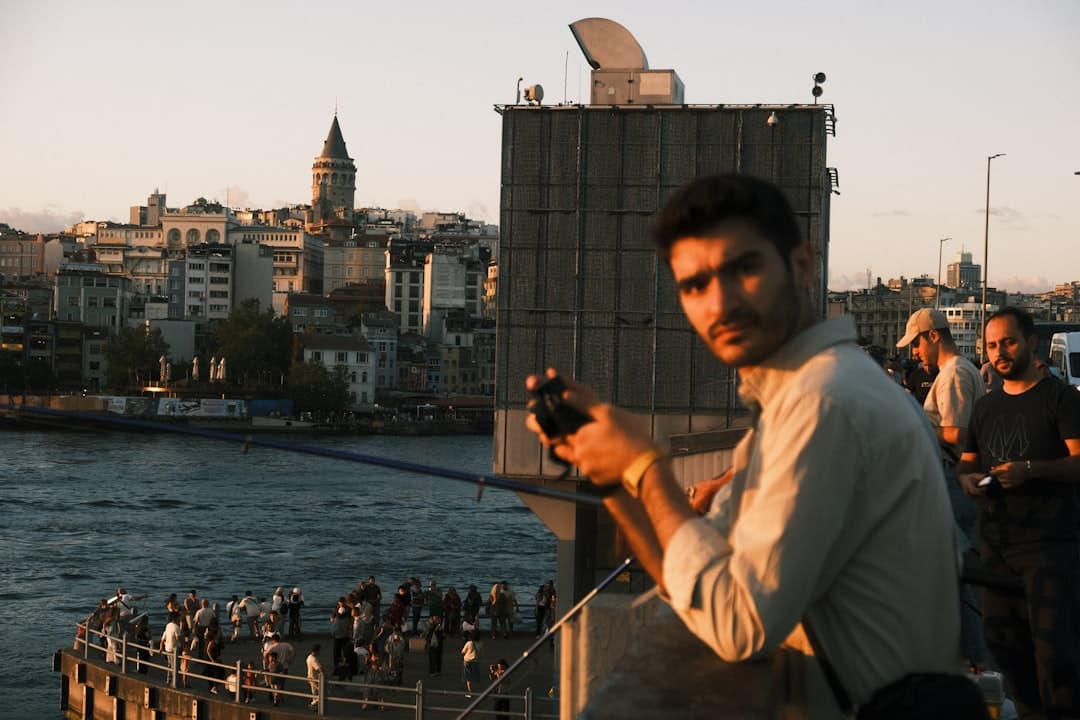 Mężczyzna na moście, Złoty Róg, Wieża Galata, Stambuł o zachodzie słońca.