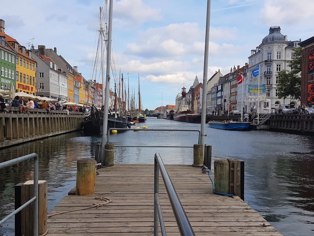 Widok na kanał Nyhavn w Kopenhadze z kolorowymi kamienicami i łodziami.