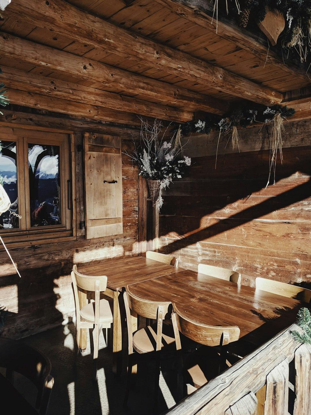 Słoneczne drewniane wnętrze restauracji górskiej z rustykalnymi meblami.
