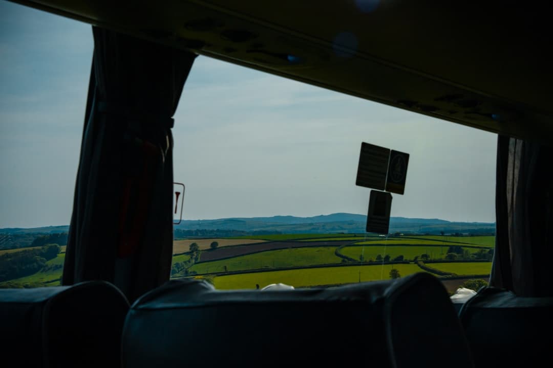 Krajobraz wiejski widziany przez okno autobusu.