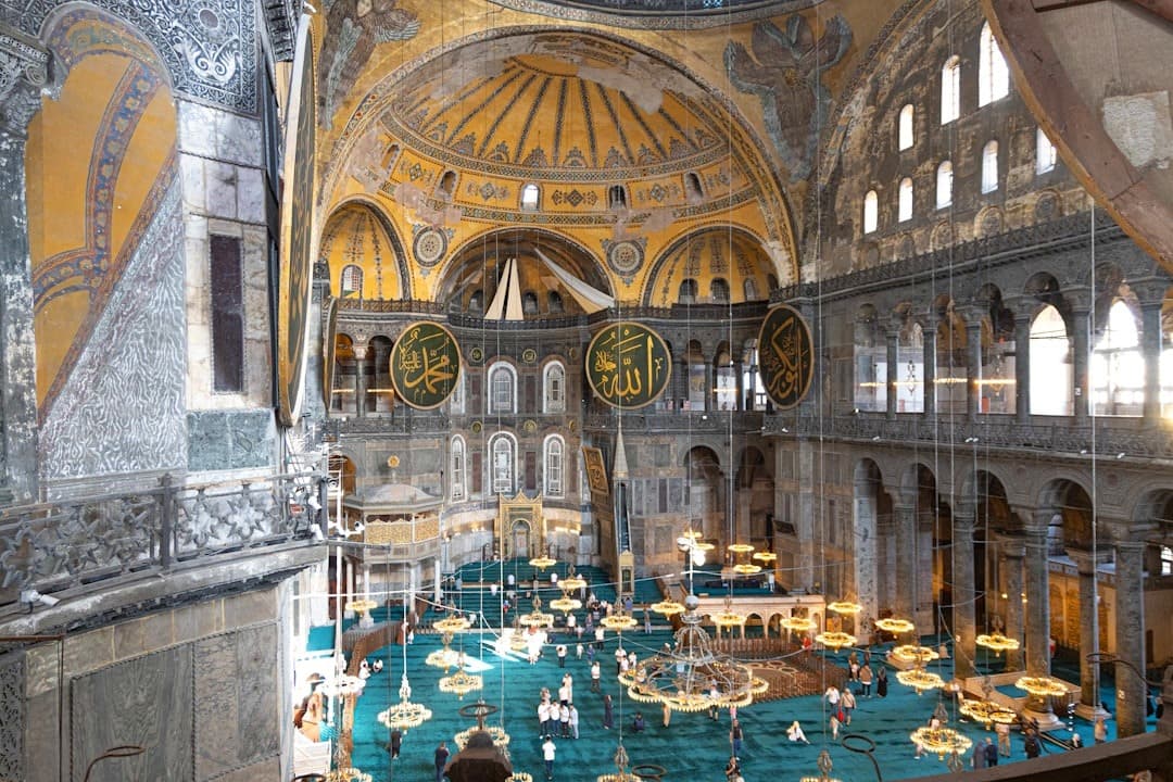 Wnętrze Hagia Sophia, Stambuł: majestatyczna kopuła, mozaiki, kaligrafia, zabytkowa architektura.