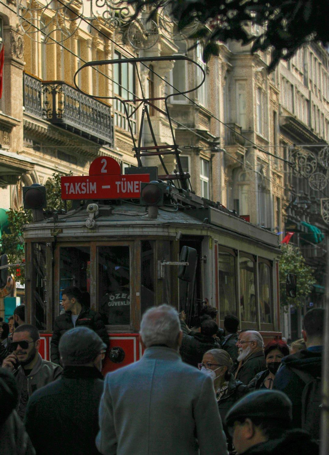 Historyczny czerwony tramwaj Taksim-Tünel na ruchliwej ulicy Stambułu.