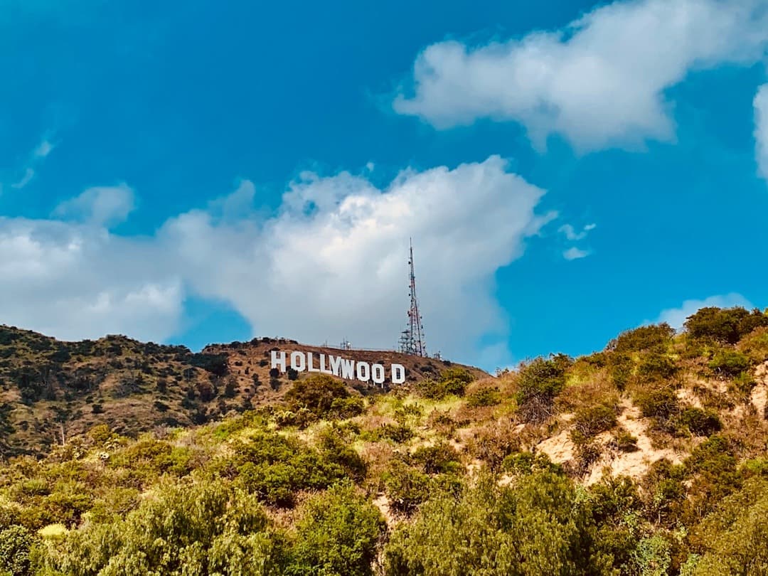 Hollywood Sign na zielonych wzgórzach Los Angeles pod błękitnym niebem.