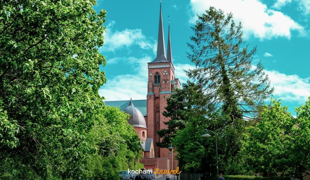 Architektura Katedry Roskilde, Dania, zielona ulica, jasne słońce