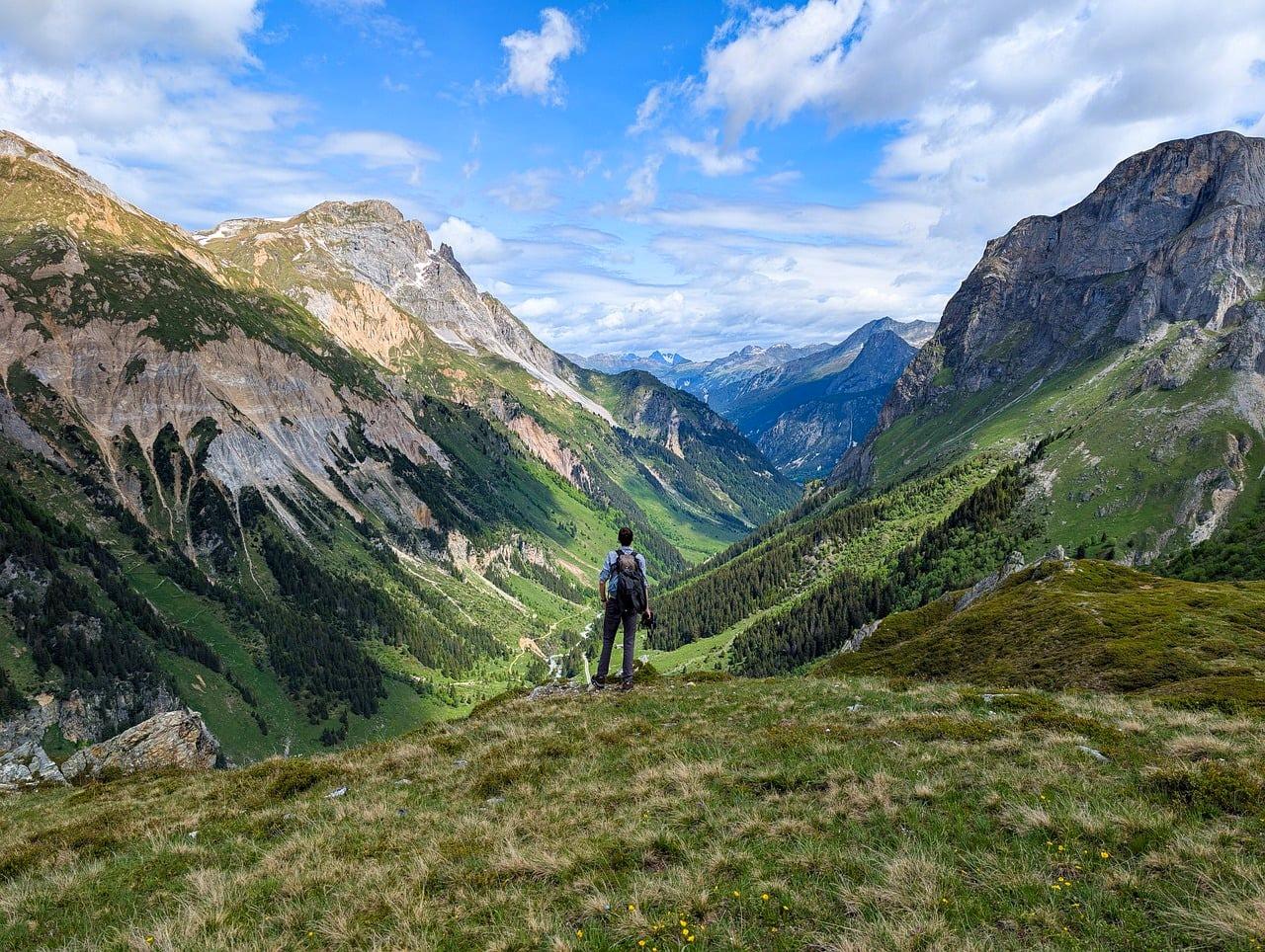 Panoramiczny widok górskiej doliny z turystą na pierwszym planie