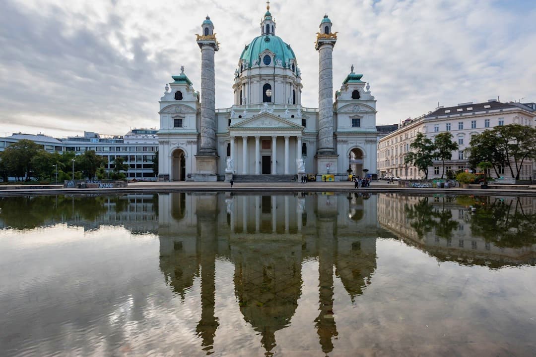 Barokowy Kościół Karlskirche w Wiedniu, odbicie w wodzie, pochmurny dzień.